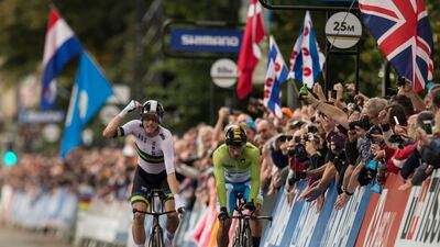 Australia's Rohan Dennis (L) gestures as he passes Slovenia's Primoz Roglic (R) and crosses the line to win the Elite Men Individual Time Trial, over 54 kms from Northallerton to Harrogate, at the 2019 UCI Road World Championships in Harrogate, northern England on September 25, 2019. / AFP / OLI SCARFF