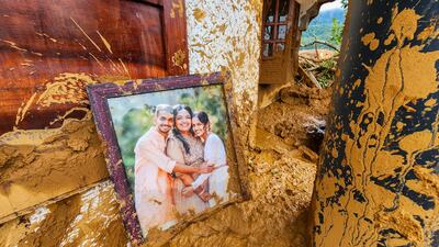 A framed photograph lies partially covered in mud at a damaged house after landslides in Wayanad district. AP