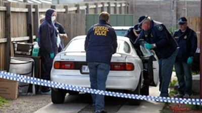 Police search a car at a Melbourne suburb after a pre-dawn raid at one of 19 locations today.