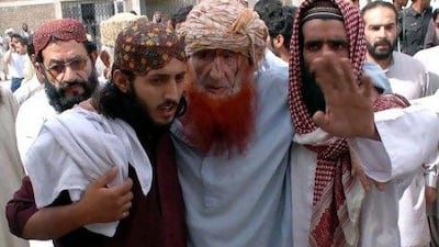 Two men assist an injured man in a bomb blast targeting a seminary in Quetta. WAHEED KHAN / EPA