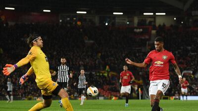 Partizan Sebian goalkeeper Vladimir Stojkovic (L) blocks a shot from Manchester United's Marcus Rashford. AFP