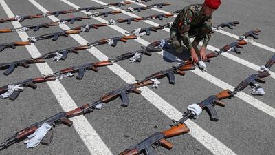 A member of the Peshmerga lays out assault rifles ahead of the officers' passing out parade in Erbil. The force is aiming to replace ageing Soviet-era equipment with Nato weapons. AFP