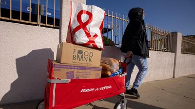 A woman leaves with a wagon of food as the Los Angeles Regional Food Bank distributes food outside a church in Los Angeles, California. Reuters