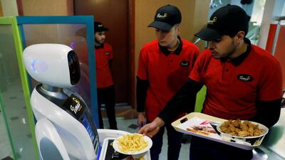 A waiter places plates with food onto the tray of Timea at the Times Fast Food restaurant. Reuters