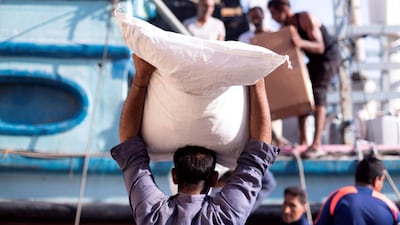Men load and unload cargo from the dhows. Reem Mohammed / The National