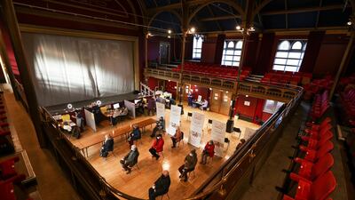 People practice social distancing as they wait to receive a dose of a Covid-19 vaccine at a community vaccination centre at Hartlepool Town Hall. Reuters