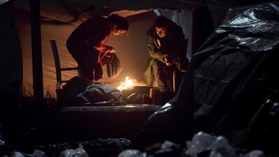 A woman dries clothing by a fire at the northern Greek border station of Idomeni. Vadim Ghirda / AP
