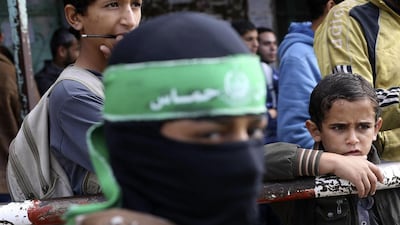 A masked boy wearing a Hamas headband joins a protest against recent visits by Jewish activists to Al Aqsa mosque. Ibraheem Abu Mustafa/Reuters