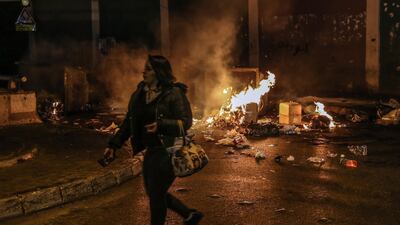 A woman passes by burning waste where supporters of Outgoing Prime Minister Saad Hariri closed the road during a protest against the newly appointed Lebanese Prime Minister Hassan Diab, at Al-Barbir neighborhood in Beirut. EPA