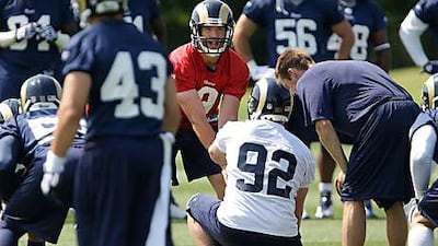 Sam Bradford, in red, calls the play during practice at a team minicamp.