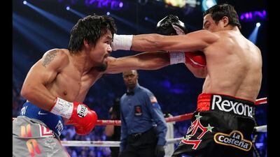 Manny Pacquiao, left, and Juan Manuel Marquez, right, trade blows during their WBO world welterweight fight. Eric Jamison / AP Photo