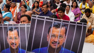 Aam Aadmi Party supporters hold up photos of leader and Delhi Chief Minister Arvind Kejriwal during a protest in India's capital. Bloomberg