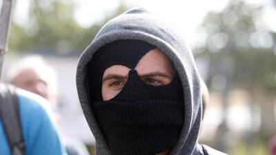 A masked Israeli settler during the evacuation. Abir Sultan / EPA