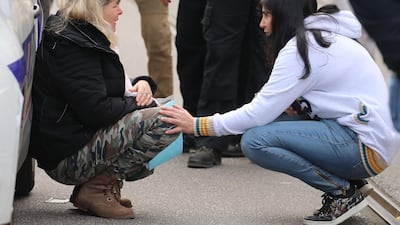 A woman kneels by a police car as she cries in Nice. AFP