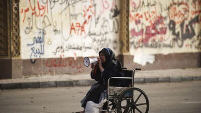 A wheelchair-bound woman shouts political slogans outside the presidential palace area in Cairo. Gianluigi Guercia / AFP