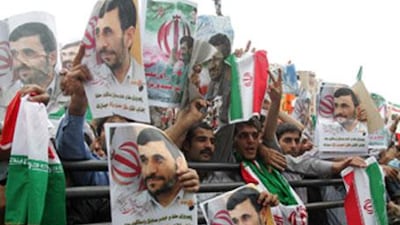 Thousands of supporters of Iran's hardline President Mahmoud Ahmadinejad (portraits) wave national flags during a massive rally to celebrate his victory in the presidential elections in Tehran's Valiasr square.