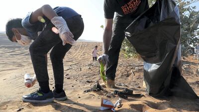 Members collect trash during the desert clean-up drive.