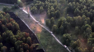 Firefighting trucks drive to a point of fire at a forest near Juterbog, Brandenburg, Germany. EPA