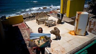 Roberto Figueroa Caballero holds a printed photo taken on October 5, 2017. Figueroa, who found a job at a pizzeria, aims to rebuild his home. Figueroa's dog was not allowed to go with him to a donated apartment where he lives now, so he visits his property daily to feed and care for him.