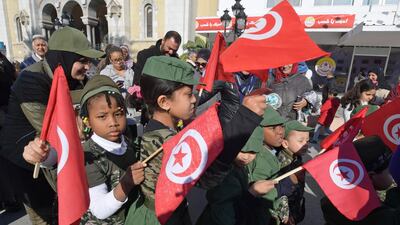 Tunisian children holding national flags take part in a rally marking the ninth anniversary of the 2011 uprising, at Habib Bourguiba Avenue in Tunis on January 14, 2020. AFP