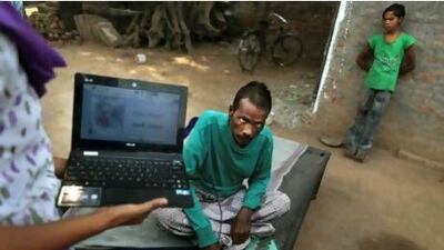 Tuberculosis patient Kallu, 36, who also suffers from HIV, gives his fingerprint to counsellor Shammo Khan as part of a programme that tracks every dose of medicine he receives.