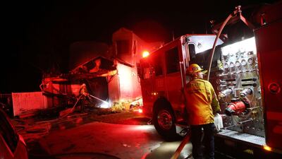 Firefighters work at a home destroyed by the Tick Fire in Canyon Country. AFP