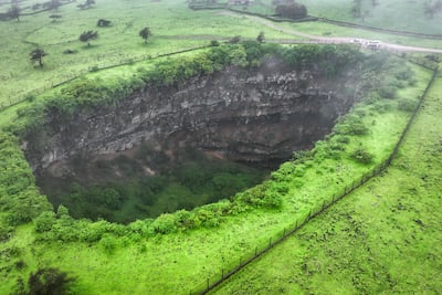 An aerial picture shows a view of the Sheeheet sinkhole in Oman's Dhofar region near the city of Taqah on July 25, 2025. (Photo by AFP)