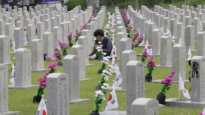 South Korean Lee Jin-yeo prays in front of the gravestone of Lee Kwan-joon, a male cousin of her father, who died during the Korean War, on Memorial Day at the National Cemetery in Seoul, South Korea. AP