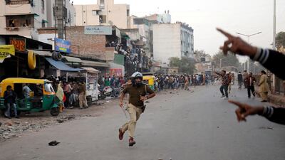 A police officer chases away demonstrators during a protest against a new citizenship law, in Ahmedabad, India.