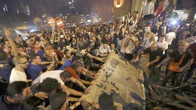 Anti-government protesters try to remove a part of a road block shutting down the route to the parliament building in downtown Beirut, Lebanon, on October 8, 2015. Bilal Hussein/AP Photo