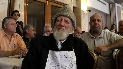 Muslim cleric Jawdat Said holds a sign which says: ‘There is an Arab solution in which nobody loses’. He was attending a public meeting of opposition figures, in the Syrian capital, Damascus, on June 27, 2011, to discuss the uprisings that began in March that year. AFP