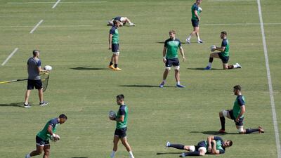 Ireland rugby team players perform stretching exercises during training. AP