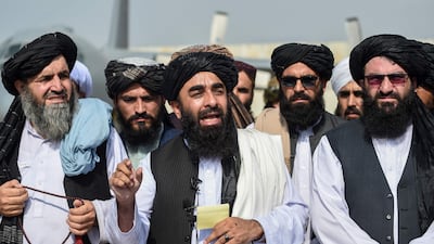 Taliban spokesman Zabihullah Mujahid, centre, addresses a media conference at the airport in Kabul. AFP