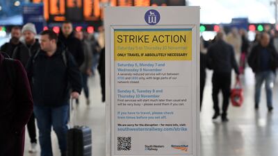 Commuters at Waterloo Station in London walk past a sign warning of strike action, which never happened. EPA