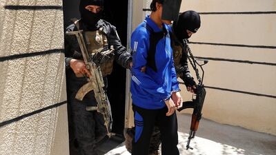 Kurdish soldiers escort a blindfolded foreign ISIL fighter at a security centre in Kobani, Syria. (AP Photo/Hussein Malla)