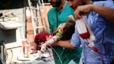 Child in time: medics carry a Syrian youngster injured in government shelling on rebels’ controlled areas of Aleppo, Syria. Carlos Palma / EPA