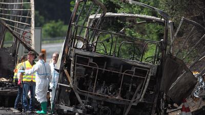 Forensic experts work on the wreckage of a bus after it crashed on the A9 highway near Muenchberg, southern Germany, on July 3, 2017. Up to 18 people were feared dead after a tour bus burst into flames following a collision with a trailer truck. Nicolas Armer / AFP