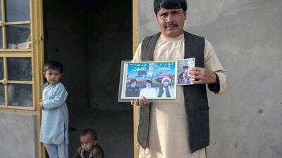 Khadija's husband holds a photo of his brothers in Helmand province - all of them killed in the conflict. Photo by Stefanie Glinski
