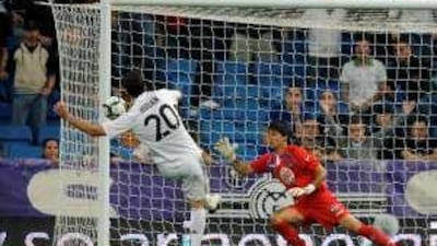 Real Madrid's Argentinian forward Gonzalo Higuain, left, scores his first goal against Getafe in the 2-0 victory at the Bernabeu on Saturday night.