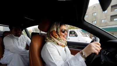 Samira al-Ghamdi, a practicing psychologist, drives to work with her son Abdulmalik, 26, sitting behind, in Jeddah, Saudi Arabia. Zohra Bensemra / Reuters