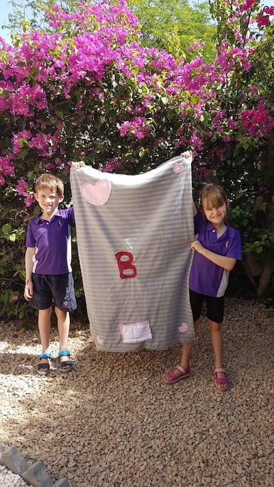 Amira and Thomas Lillywhite hold up the fleece blanket they made for their family pet. Courtesy - Hannah Lillywhite