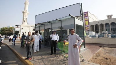 Passengers wait outside a bus shelter with malfunctioning air conditioning in Abu Dhabi. Photo: Ravindranath K / The National