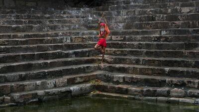 A Sadhu or Hindu holy man performs yoga on the steps of Saubhagya Kund, a holy pond, at the Kamakhya temple in Gauhati. Anupam Nath / AP Photo