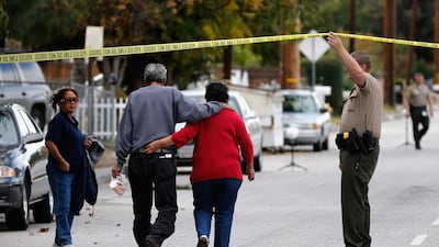 A police officer lets residents into San Bernadino Avenue, the scene of a mass shooting in California (Sean M. Haffey/Getty Images/AFP)