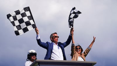 US Secretary of Transportation Sean Duffy and his wife, Rachel Campos-Duffy, wave the checkered flags at the end of the race. Reuters