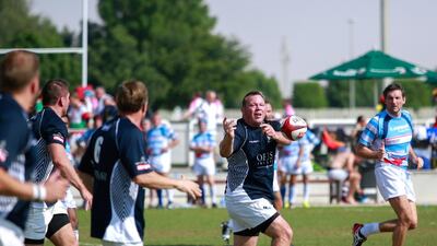 Gulf Legends (dark blue) v Airbus (light blue stripes): Steve Thompson passes the ball during Day 1 of the Emirates Airlines Dubai Rugby Sevens at The Sevens in Dubai on Thursday. Victor Besa for The National