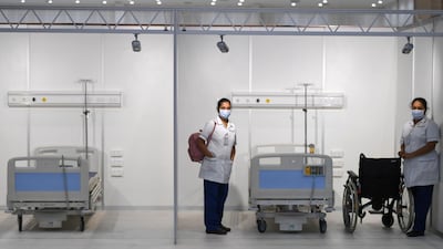 Nurses pose for a picture as they prepare beds at the huge field hospital
