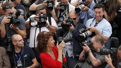Actress Sophia Loren, centre, guest of honour, holds a camera as she sits with assembled photographers during a photocall for the film La Voce Umana presented as part of Cannes Classics at in competition at the 67th Cannes Film Festival in Cannes May 21, 2014. Regis Duvignau / Reuters