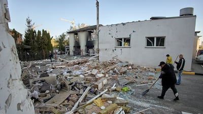 Workers clean debris after an administrative building was damaged in a rocket attack in Kharkiv. EPA