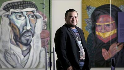 Philippine artist Janos De La Cruz poses for a portrait with his artwork Enclosed Photo #2 and Enclosed Photo #3, both acrylic on canvas, during the opening for the Philippine Art Month.